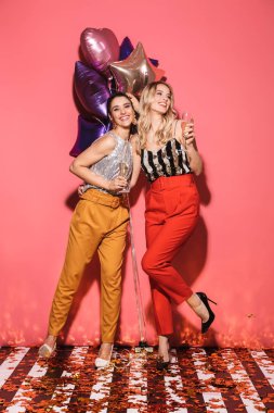 İki mutlu kadınlar 20'li yaşlarda Festival b tutan şık kıyafetiyle fotoğrafı