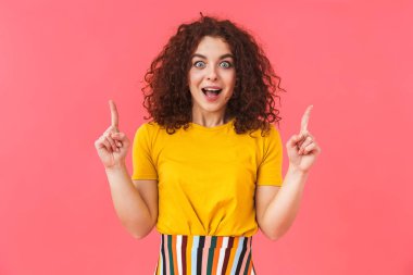 Güzel genç kıvırcık kız arka plan kırmızı duvar işaret içinde izole poz.