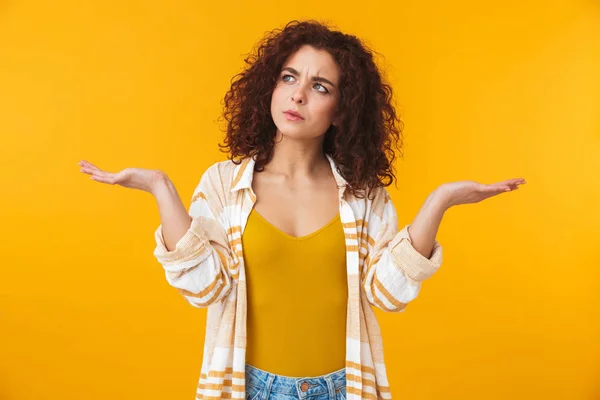 Imagem de mulher confusa 20s com cabelo encaracolado jogando as mãos para cima — Fotografia de Stock