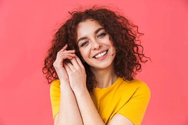 Linda chica rizada hermosa feliz posando aislado sobre fondo de pared roja . — Foto de Stock