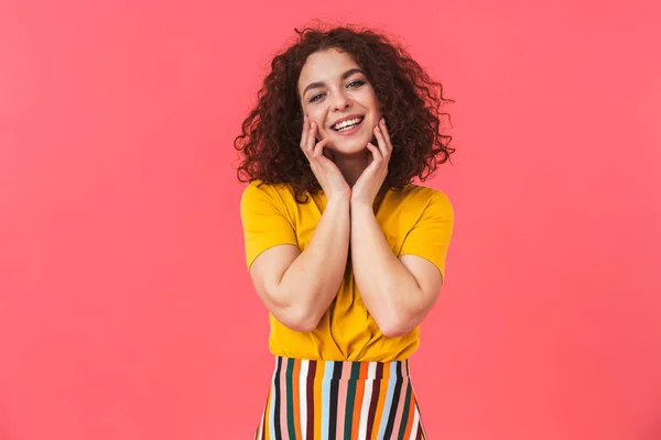 Linda chica rizada hermosa feliz posando aislado sobre fondo de pared roja . — Foto de Stock