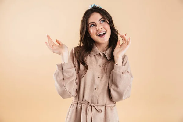 Linda animado surpreso jovem bonita mulher posando isolado sobre parede de fundo bege . — Fotografia de Stock