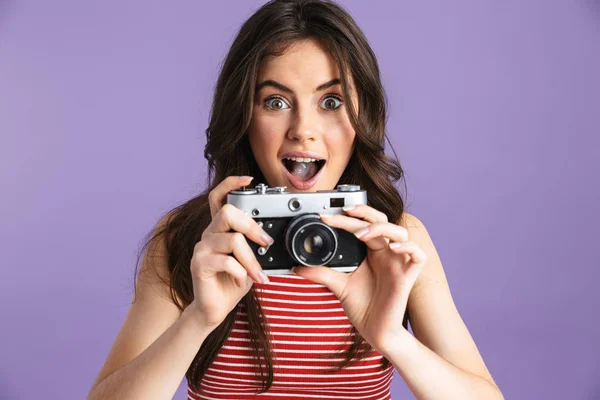 Gelukkig mooie jongedame fotograaf poseren geïsoleerde over paarse achtergrond muur houden van de camera. — Stockfoto