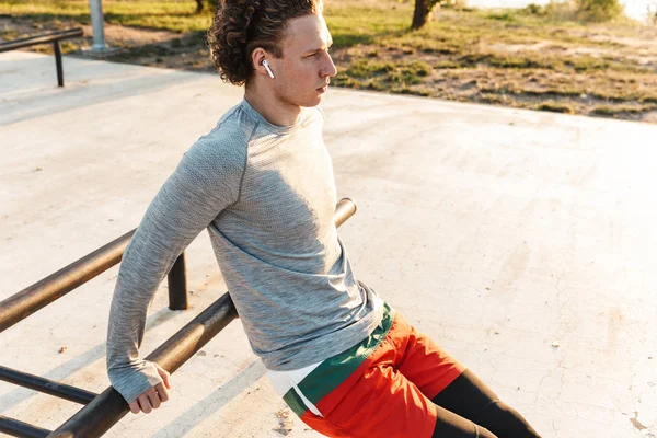 Jovem desportista confiante fazendo exercícios ao ar livre — Fotografia de Stock