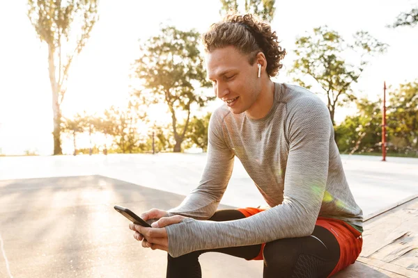 Sportivo sorridente con gli auricolari — Foto Stock