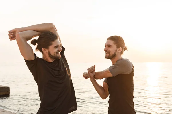 Dos hermanos gemelos haciendo ejercicios en la playa — Foto de Stock