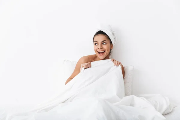 Vidám fiatal nő az ágyban ülve zuhany után — Stock Fotó