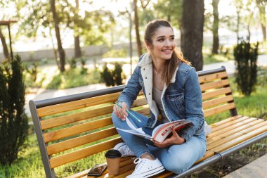 Gülümseyen genç kadın ceket ve güneş gözlüğü giyiyor