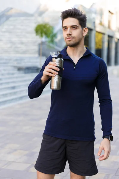 Jovem desportista confiante segurando garrafa de água — Fotografia de Stock