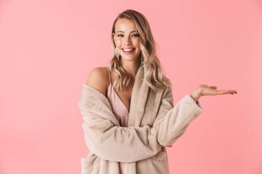 Güzel kadın moda ceket giymiş pembe duvar arka plan üzerinde izole poz.