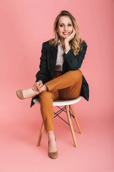 Фото молодой деловой женщины, улыбающейся и сидящей в кресле-изоляте — стоковое фото