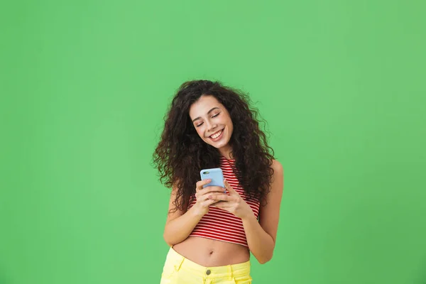 Фотография радостной женщины, улыбающейся и использующей мобильный телефон изолированы над — стоковое фото