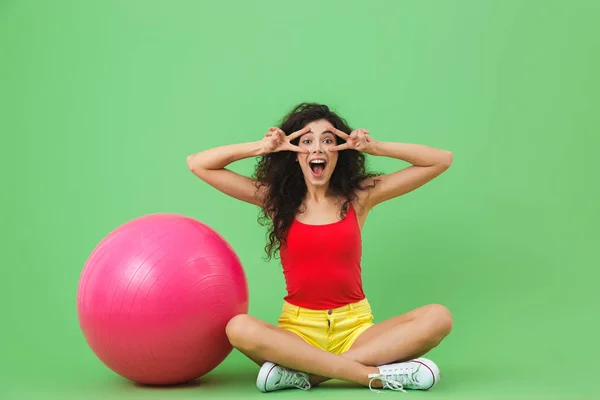 Bild av ung kvinna sitter på golvet med Fitness boll under en — Stockfoto