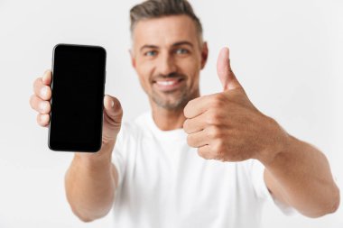 Rahat t-shirt tutarak ve iblisler giyen mutlu adam 30s görüntü