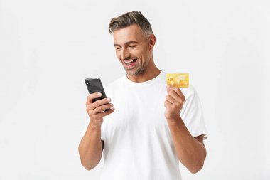 Rahat t-shirt tutan smartph giyen tıraş edilmemiş adam 30s görüntü