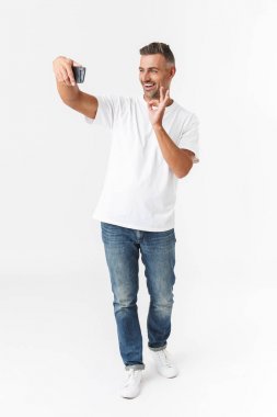 Rahat t-shirt giyen tıraş edilmemiş adam 30s tam uzunlukta görüntü ve