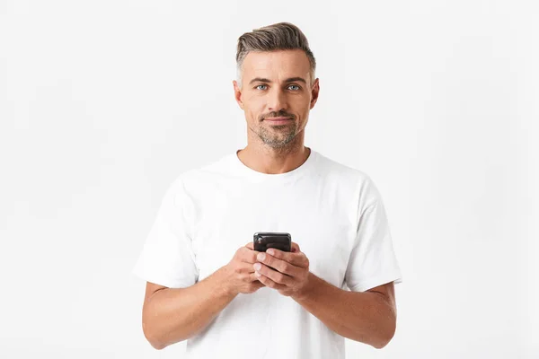 Imagen del hombre musculoso de 30 años con camiseta casual sosteniendo y usi — Foto de Stock