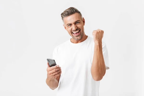 Imagem de homem alegre 30 anos vestindo casual t-shirt regozijando-se enquanto u — Fotografia de Stock