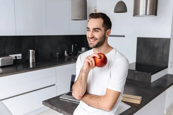 Jovem sorridente segurando uma maçã — Fotografia de Stock