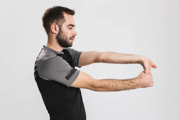 Young sports fitness man posing isolate over white wall background make stretching exercises. — Stock Photo, Image