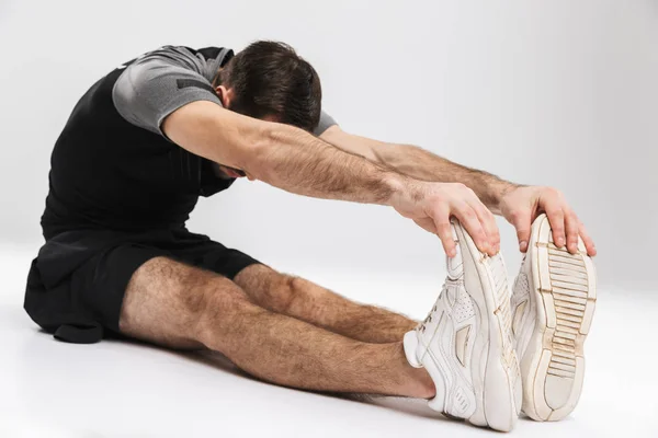 Sports fitness man isolate over white wall background make stretching exercises. — Stock Photo, Image