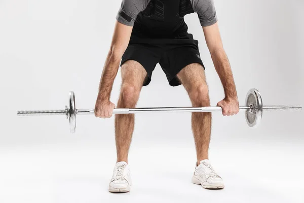 Joven deportista fitness hombre aislar sobre fondo blanco de la pared hacer ejercicios con barra . — Foto de Stock