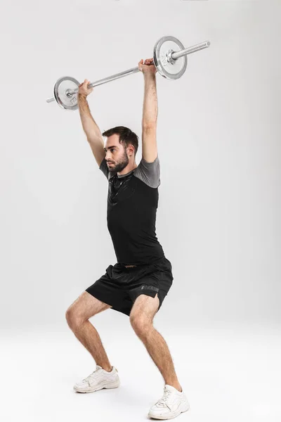 Νέοι Αθλητισμός Fitness άνθρωπος απομονώνεται πάνω από λευκό τοίχο φόντο κάνει ασκήσεις με μπάρα. — Φωτογραφία Αρχείου