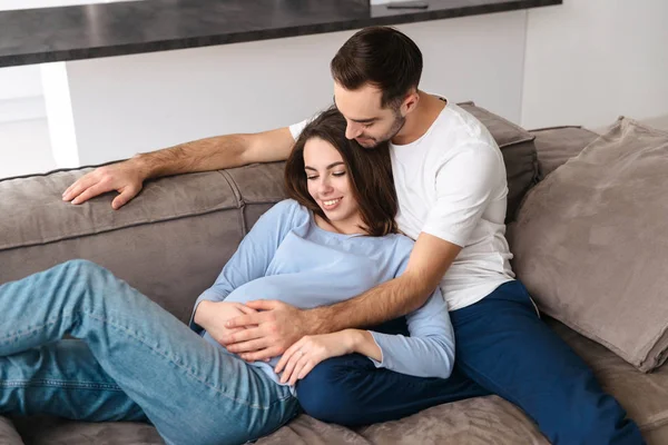 Образ кавказької вагітної жінки і красивого чоловіка вдома лежить — стокове фото