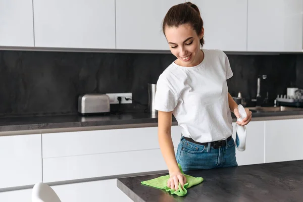 Attraktiv ung kvinna rengöring kök — Stockfoto