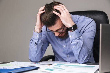 Kafasını tutan stres içinde gözlüklü sakallı zarif adam