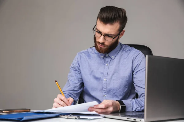 Hombre elegante barbudo concentrado en anteojos escribiendo algo — Foto de Stock