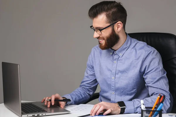 Sonriente barbudo hombre elegante en gafas con ordenador portátil — Foto de Stock