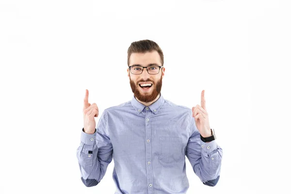 Alegre barbudo elegante hombre en gafas apuntando hacia arriba — Foto de Stock