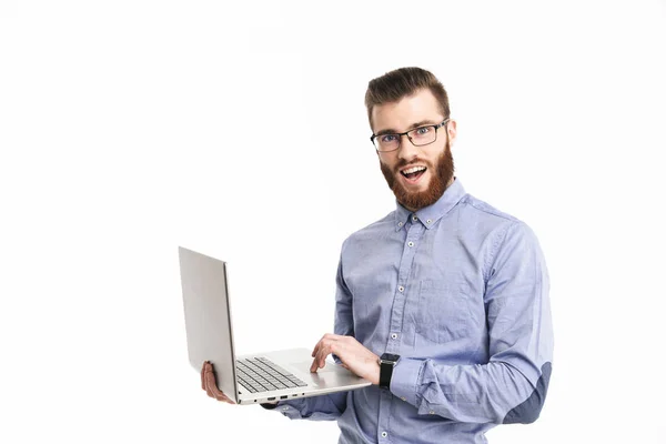 Sorrindo barbudo homem elegante em óculos segurando computador portátil — Fotografia de Stock