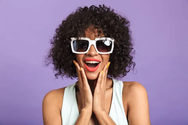 Glad ganska afrikansk kvinna i solglasögon vidrör hennes kinder — Stockfoto