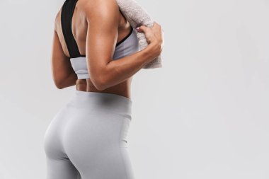 Güzel genç inanılmaz güçlü spor fitness kadın beyaz duvar arka plan havlu tutarak üzerinde izole poz.