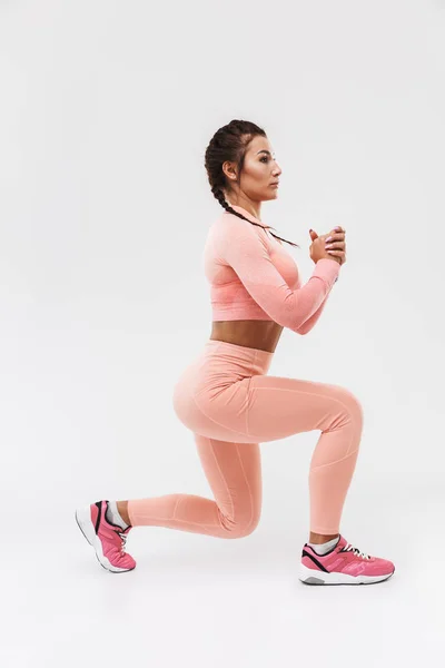 Joven increíble deporte fuerte fitness mujer posando aislado sobre fondo blanco de la pared hacer ejercicios . — Foto de Stock