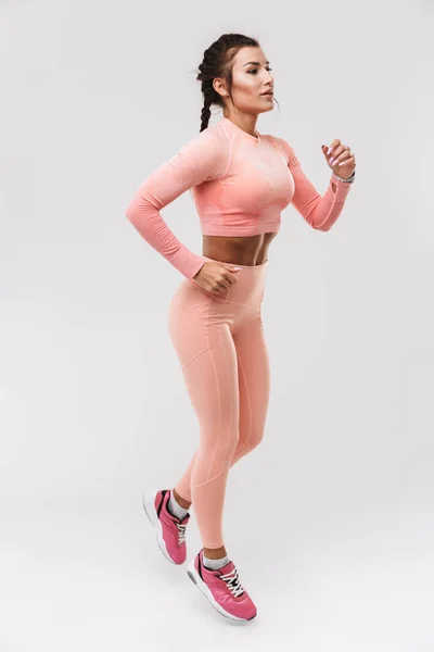 Joven increíble deporte fuerte fitness mujer posando aislado sobre fondo blanco de la pared hacer ejercicios . — Foto de Stock