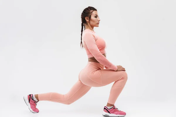 Junge erstaunliche starke Sport Fitness Frau posiert isoliert über weiße Wand Hintergrund machen Übungen. — Stockfoto