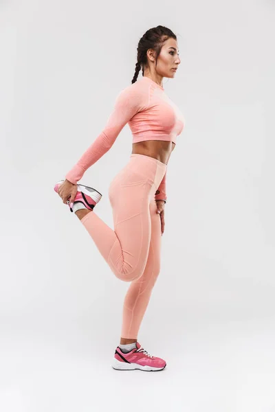 Ung fantastisk stark sport fitness kvinna poserar isolerad över vit vägg bakgrund göra övningar. — Stockfoto