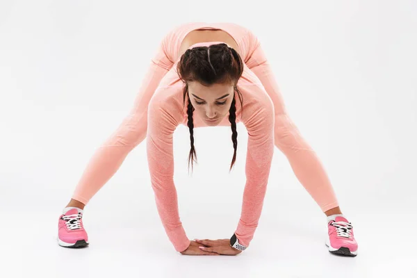 Joven increíble deporte fuerte fitness mujer posando aislado sobre fondo blanco de la pared hacer ejercicios . — Foto de Stock