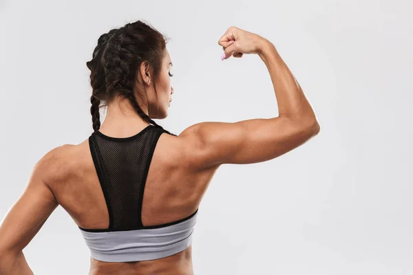 Incrível forte esportes fitness mulher posando isolado sobre fundo da parede branca . — Fotografia de Stock