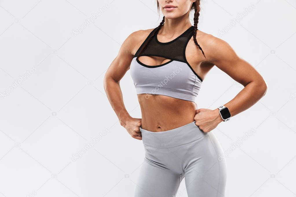 Amazing strong sports fitness woman posing isolated over white wall background.