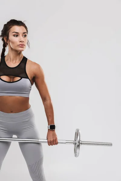 Jovem incrível forte esportes fitness mulher posando isolado sobre fundo da parede branca fazer exercícios com barra . — Fotografia de Stock