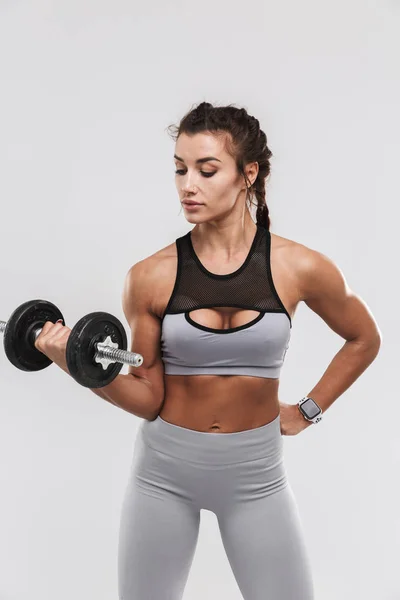 Bonito jovem incrível forte esportes fitness mulher posando isolado sobre fundo de parede branca fazer exercícios com haltere . — Fotografia de Stock