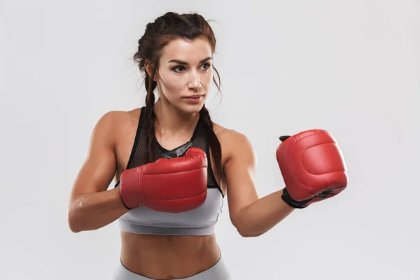 Hermosa joven increíble deporte fuerte fitness mujer boxeador posando aislado sobre fondo de pared blanca hacer ejercicios con guantes . — Foto de Stock