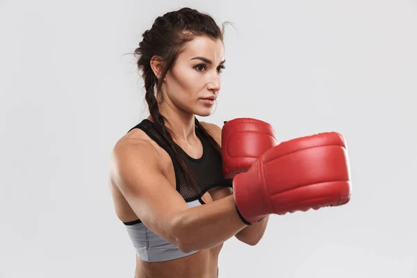 Hermosa joven increíble deporte fuerte fitness mujer boxeador posando aislado sobre fondo de pared blanca hacer ejercicios con guantes . — Foto de Stock