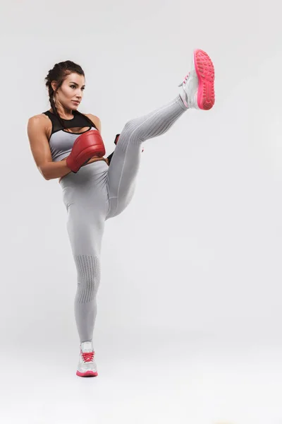 美丽的年轻惊人的强大的运动健身女拳击手姿势孤立在白墙背景做手套练习. — 图库照片