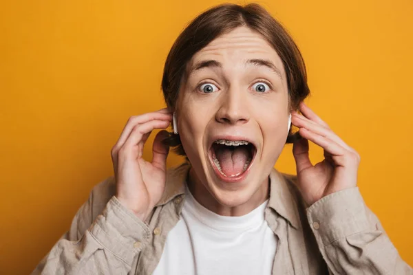 Närbild av en upphetsad tonårs pojke som bär hörlurar — Stockfoto