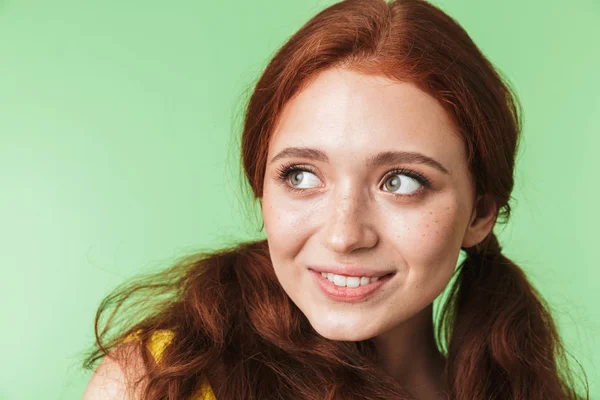녹색 벽 배경을 통해 고립 된 포즈를 취하는 아름다운 행복한 젊은 빨간 머리 소녀. — 스톡 사진